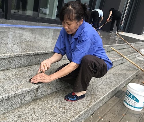 清卫员付仙云擦洗新寝室楼外台阶.